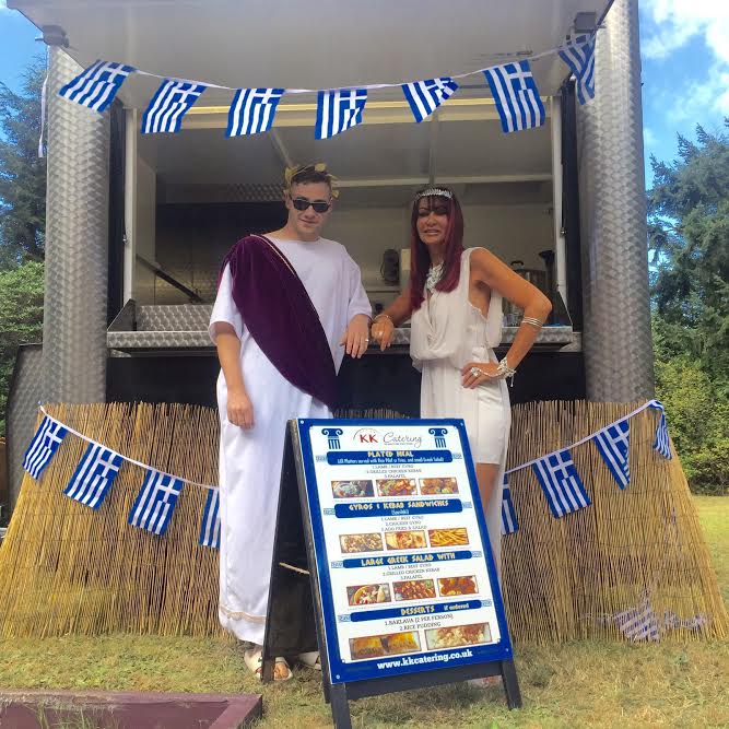 couple standing in front of Greek Souvlaki hut