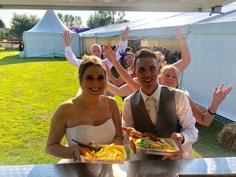 bride and groom with fish and chips at their wedding breakfast