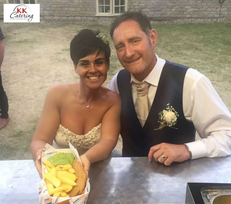 bride and groom with fish and chips at their wedding from a fish and chip van