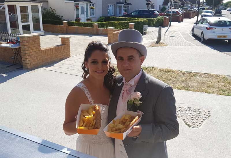 bride and groom with fish and chips on wedding day