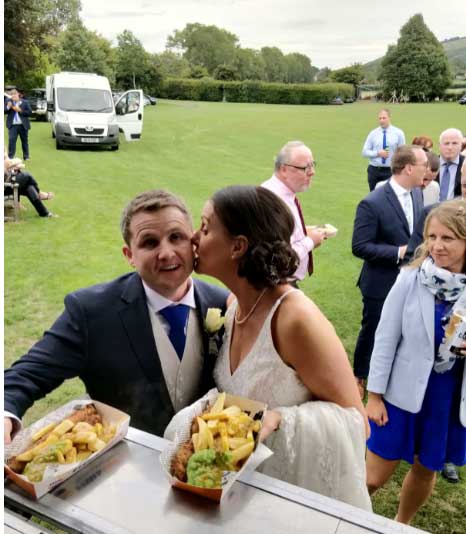 bride kissing groom at fish and chip van