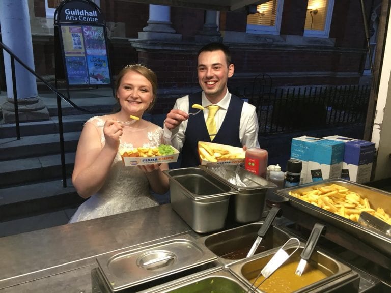 bride groom eating fish and chips at their wedding with kk catering