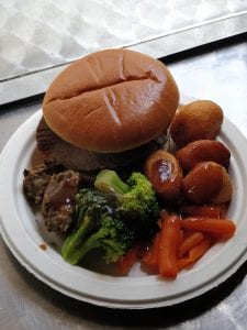 Roast beef sandwich with broccoli carrots roast potatoes and gravy