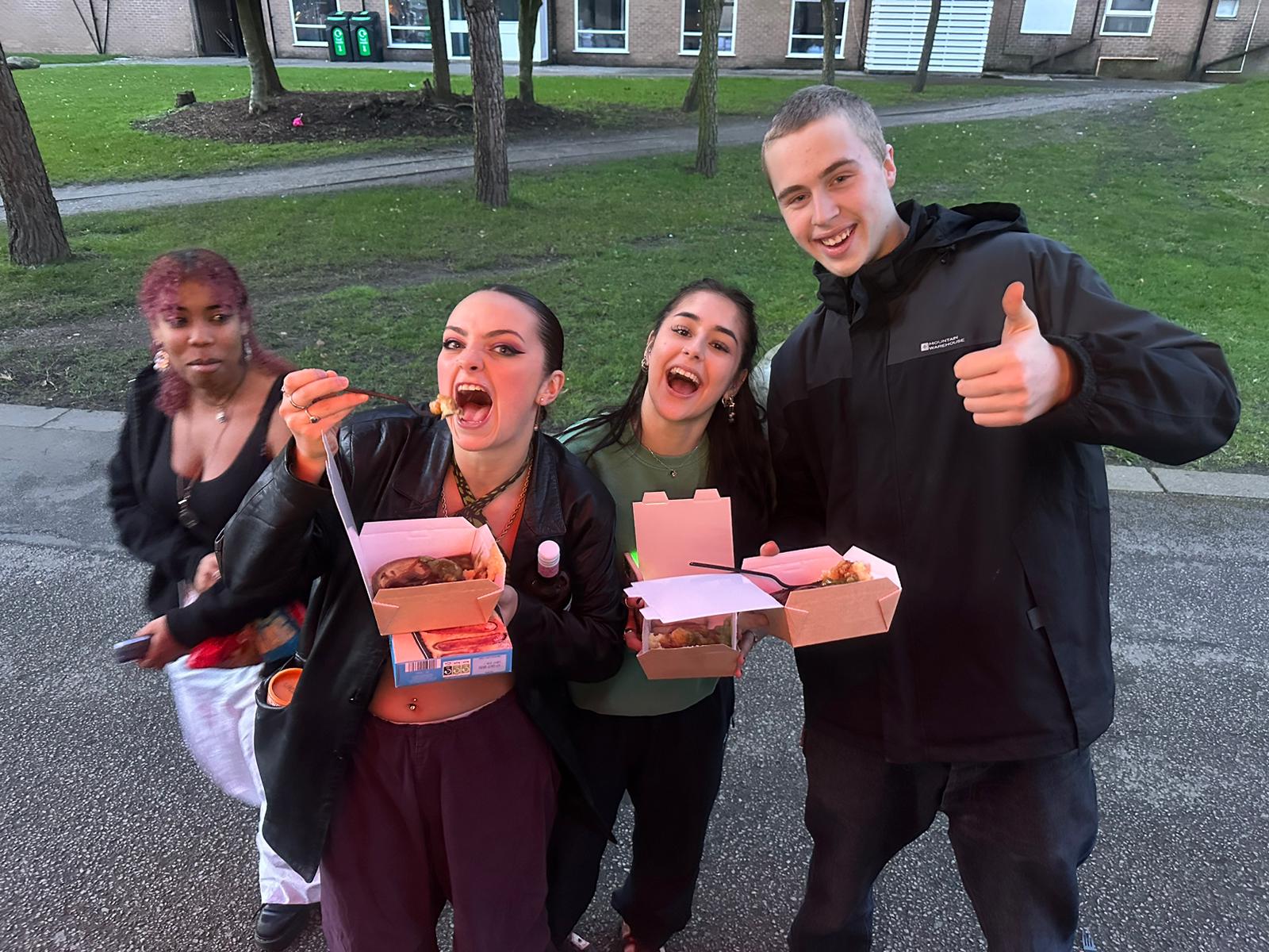 students at manchester university giving a thumbs up to their pie and mash