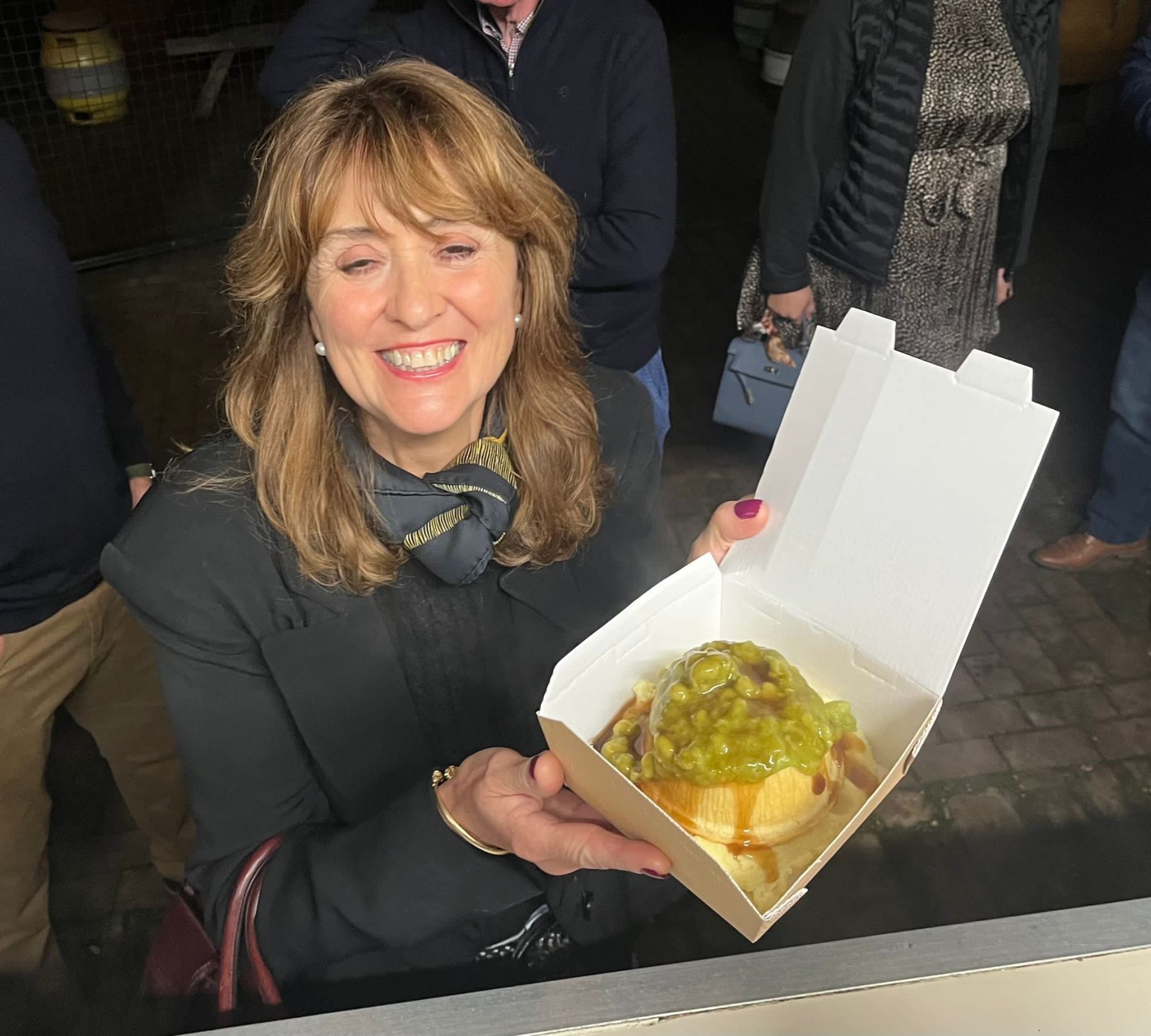 a woman collecting her pie and mash from the kk catering pie and mash food van